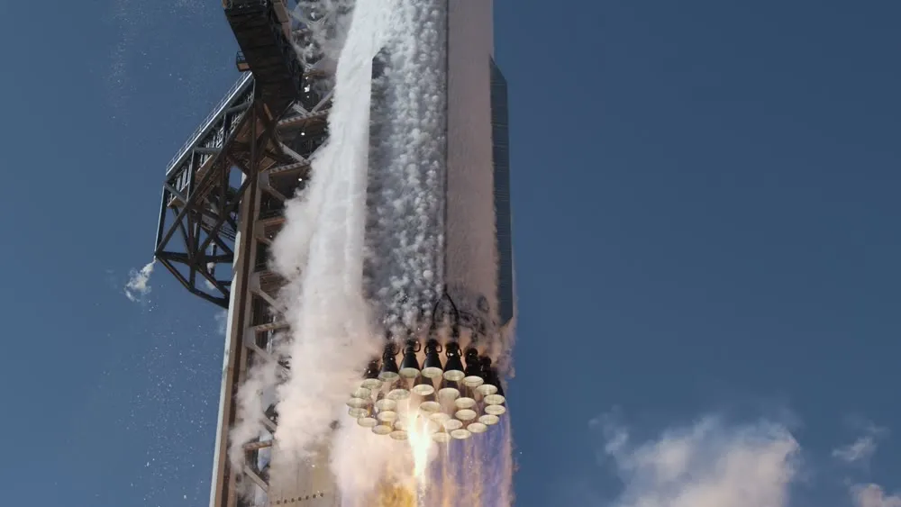 Super Heavy lifting away from the launch tower with its Raptor engines firing